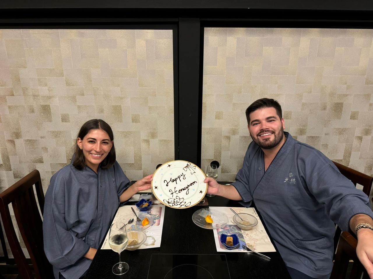 Pareja celebrando su honeymoon con un plato conmemorativo